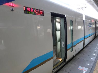 Tren, şehirdeki platformda hareketsiz duruyor.