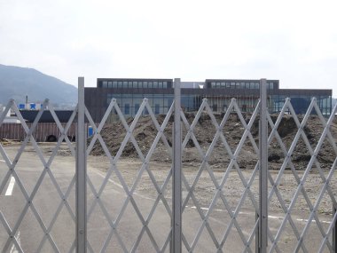 Metal çit, modern binanın dış görünüşünü engelliyor.