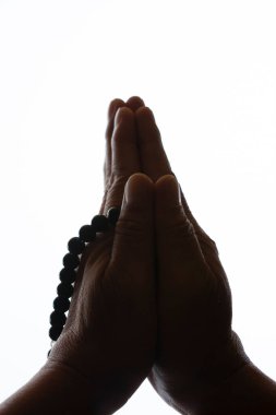 Beyaz arka planda tespihi tutan eller