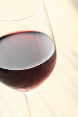 Ahşap bir masada kırmızı şarap bardağı, yakın plan.         