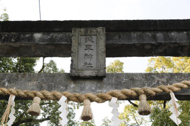 Halat ve kağıt şeritli taş torii kapısı
