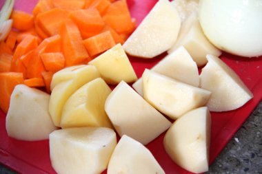 Beyaz arka planda dilimlenmiş havuç ve patates.