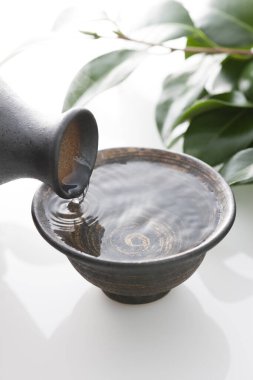 Japon sake 'sini şişeden killi fincana dök