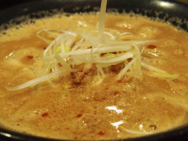 Dilimlenmiş soğanla buğulanmış miso ramen.