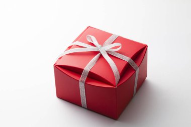 Beyaz arkaplanda kurdeleli hediye kutusunun yakın plan görüntüsü.           