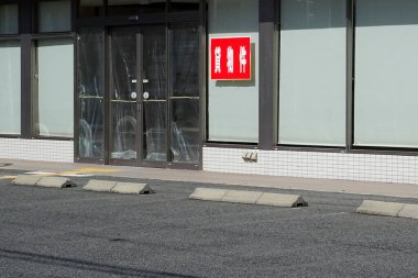 Kapalı cam kapılar ve kırmızı tabelanın yanında boş park yeri