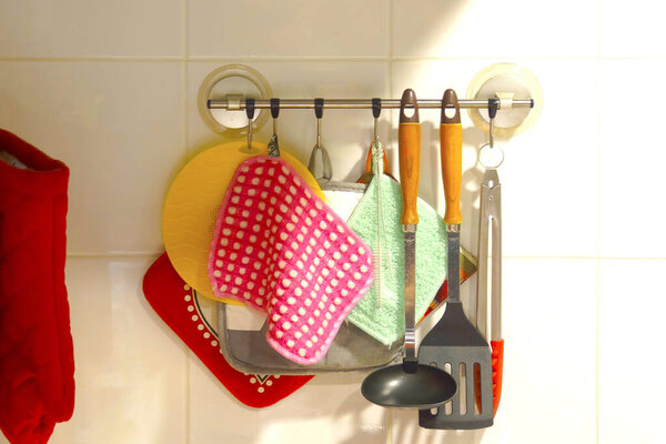 Colorful kitchen utensils hanging on wall rack