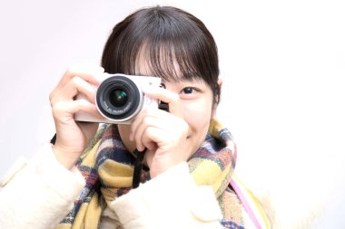 Asyalı kadın klasik kamerayla fotoğraf çekiyor.