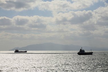 Gökyüzünde bulutlar ve gemilerle denize güzel bir manzara           