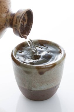 Japon sake 'sini şişeden killi fincana dök