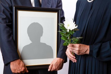 Cenaze çerçevesini erkek siluetiyle tutan kişinin yakın görüntüsü 