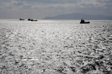 Gökyüzünde bulutlar ve gemilerle denize güzel bir manzara           