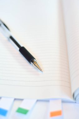 Masa arkasında kalem olan boş bir defter, kapat