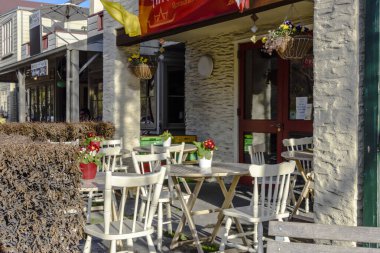 Beyaz sandalyeli güneşli açık hava kafe.