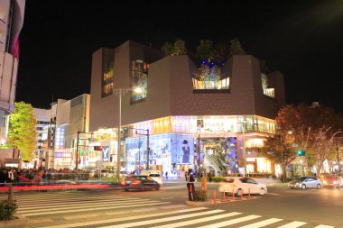 İnsanlar geceleri Tokyo 'da şehir caddesinde yürür.      