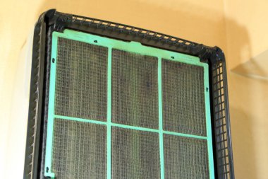 Kapalı alanda temizlenmesi gereken tozlu klima filtresi görünüyor.