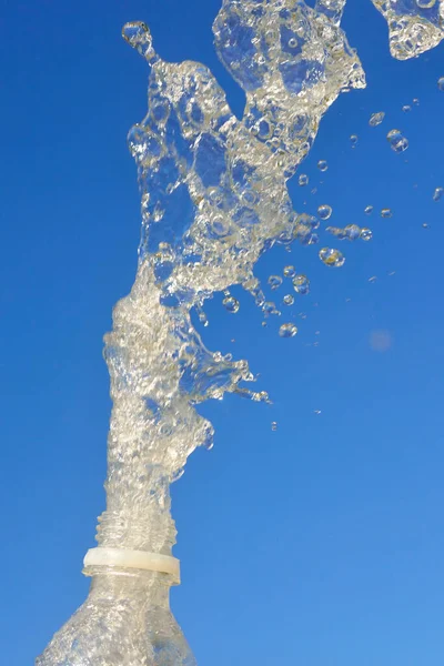 青空の背景にボトルからきれいな水が飛び散る — ストック写真