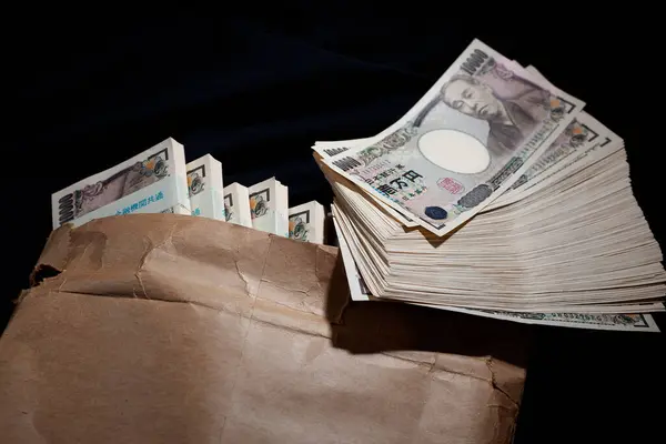 Japanese currency, pile of yen banknotes in paper bag