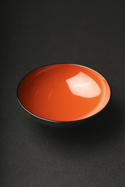 Koyu yüzeyde turuncu seramik kase