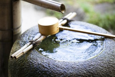 Tahta kepçeli geleneksel bambu çeşmesi