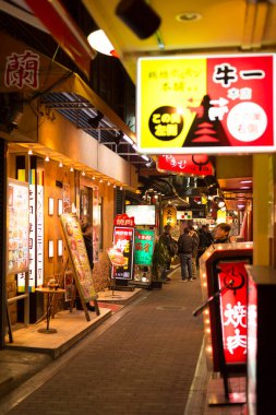 Japon şehrinde insanlar geceleri sokakta yürüyorlar.