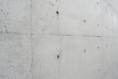 Gri beton yüzeyi olan beyaz bir beton duvar.