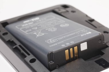 Beyaz arkaplanda pil ve cep telefonu var.