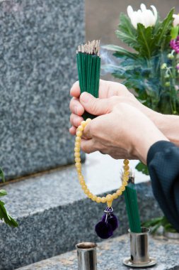 Japon cenaze gelenekleri, Sogi cenaze töreninde yanan tütsü çubukları tutan kişi. 