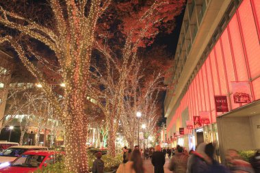 Noel süslerinin ve çelenklerin güzel manzarası gece şehrinde ağaçlarda                    