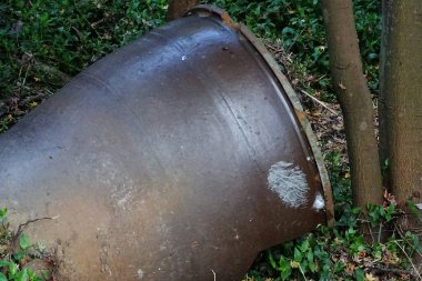 Büyük saplı paslı metal fıçı.