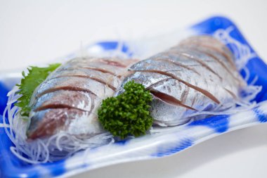 Dilimlenmiş tuzlu ringa balığı ve otlar. 