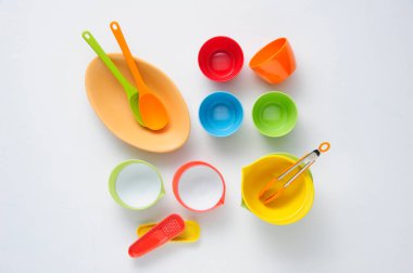 Beyaz arkaplanda renkli plastik sofra takımı