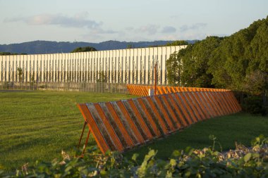 Yeşil çimen tarlasına yaslanmış turuncu ahşap yapı