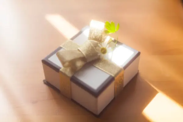 gift box with flower and ribbon on background