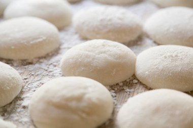 Un kaplı yüzeyde dinlenen yuvarlak hamur topları