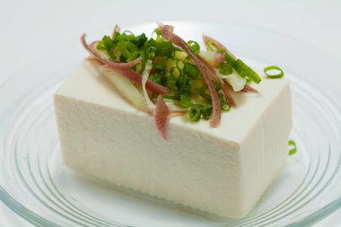 Üstünde yeşil lahanalar olan bir parça peynir.