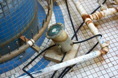 Eski su altı havuzu aydınlatma tesisatını çevreleyen paslı borular.