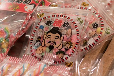 Neşeli çizgi film yüzleri içeren renkli Japon şekerleme paketleri