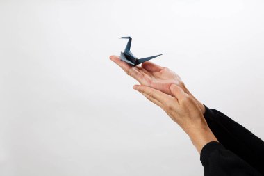 İnsan eli kağıt tutar, origami kuşu. 