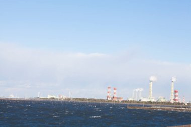 Sahil şeridi yakınlarındaki sanayi binaları açık mavi gökyüzünün altında