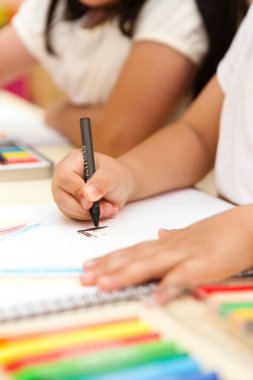 Sınıfta resim çizen iki konsantre Asyalı küçük kız.