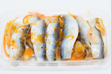 a plastic container filled with fish and sauce