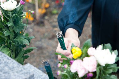 Mezarlık arka planında tütsü kalıntılarının yakın görüntüsü