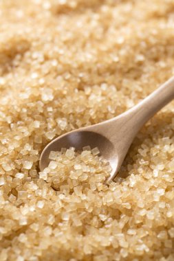 Esmer şeker ve tahta kaşık arka planda, kapatın.