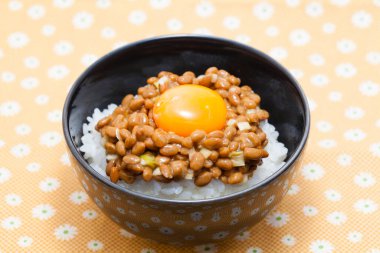 Fasulyeli çiğ yumurta sarısı ve kasede pilav, geleneksel Asya yemekleri.