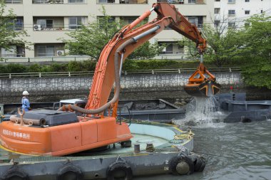 Kazıcı nehirden su yolu kaldırma malzemeleri üzerinde çalışıyor