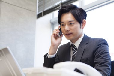 Asyalı iş adamı dizüstü bilgisayarla çalışıyor