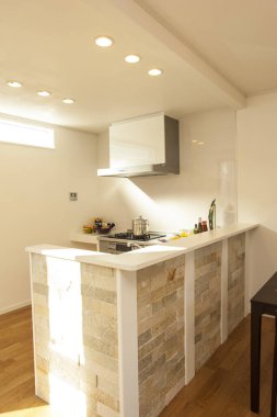 Taş adası ve ahşap zemini olan modern bir mutfak.