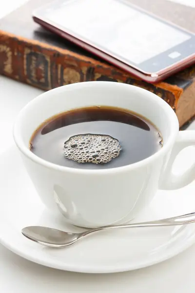cup of coffee, book and phone on white table background, close-up view