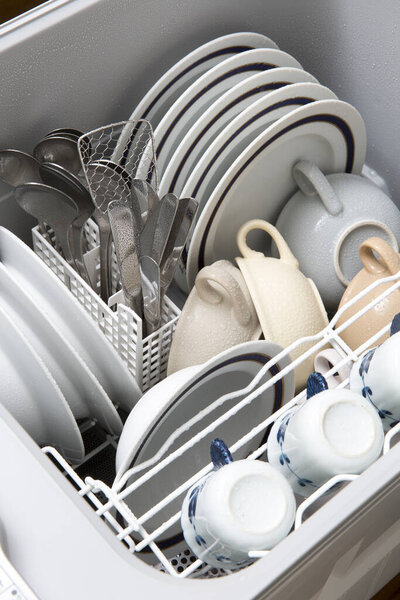 clean dishes in open dishwasher, close up view